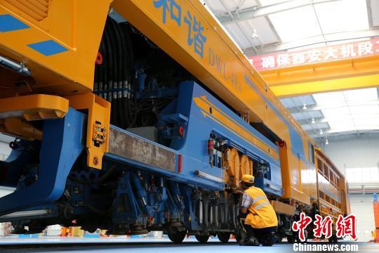 圖為工人正在清理大型養(yǎng)路機(jī)械?！堖h(yuǎn) 攝